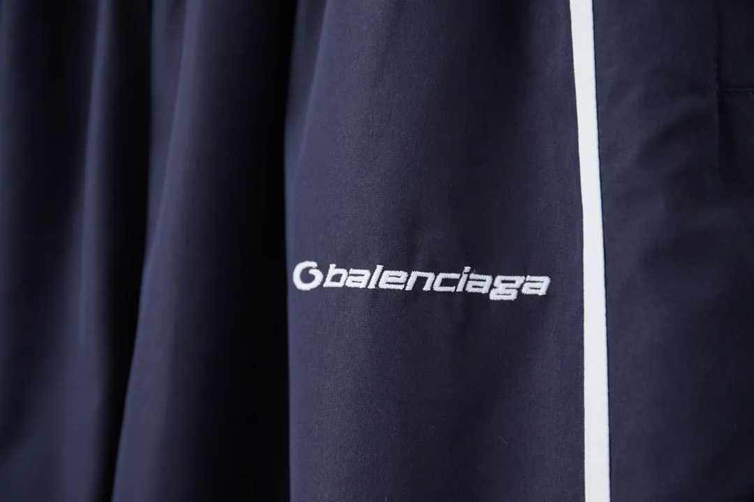 Balenciaga 𝘽𝘼𝙇𝙀𝙉𝘾𝙄𝘼𝙂𝘼 BLCG 25SS double-split waterproof sports pants. Light luxury. A must-have item for daily commuting for men and women. Correct version. Welcome to compare. Detailed features · Customized matt Taslan jacket fabric · The entire fabric is pre-treated with a waterproof coating · The interior is made of three-level polyester bird's eye mesh · OS ultra-loose silhouette design · Side pockets · Elastic waistband design · Contrast color Black webbing splicing · Front and rear contrast color splicing and cutting design · Imported Tajima machine embroidery ring logo · Original main mark washed tag brand packaging Color: White/Royal Blue Size: 46/48/50/52
